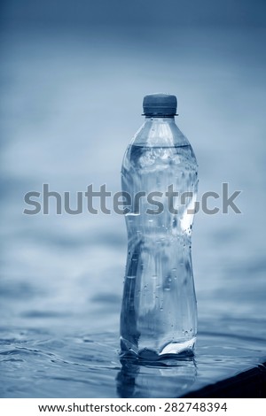PET bottle with water on a water surface background