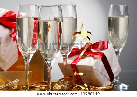 Glasses of champagne, gifts with red tapes and bows