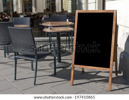 Empty menu board stand and outdoor cafe