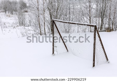Old abandoned wooden soccer goal covered with snow during winter season