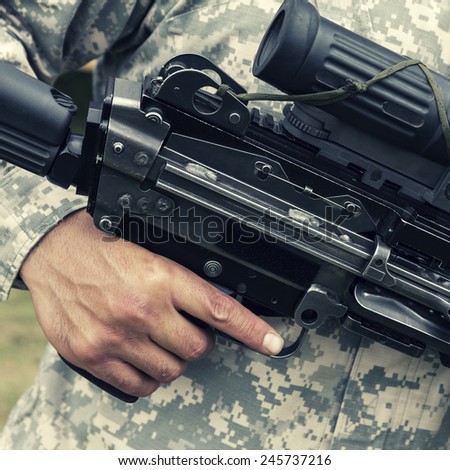 Colorized picture of soldier holding his finger on trigger of automatic gun