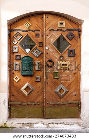 Vertical oriented picture of wooden shop doors decorated with a set of antique picture frames. Original shot made in Vilnius, capital of Lithuania