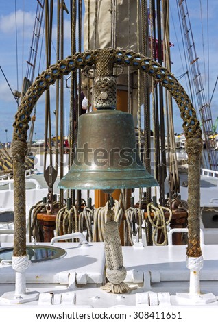 Closeup of ship deck with sail ropes and old bell made of copper