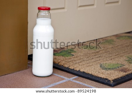 Milk bottle standing at doorway