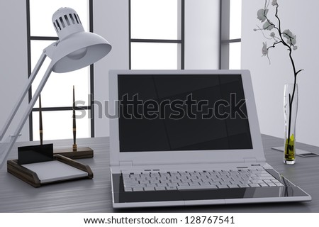 laptop and flower in vase on table in modern cubicle