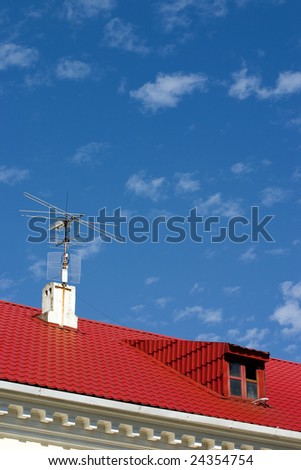 brightly red roof with a dormer on a background blue sky