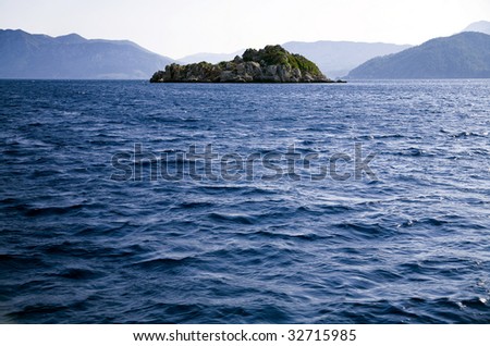 blue waves of Mediterranean on a background mountains island and sky