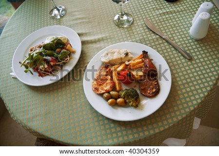 delicious meat and vegetable dishes on the table of restaurant
