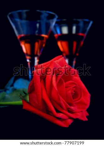 Gentle red rose and liquor in a glasses on a black background