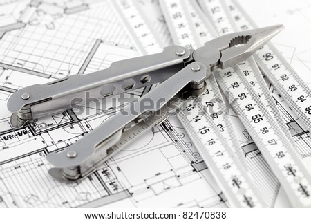 Pliers,  metric folding ruler and architectural plan of the modern house