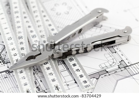 Pliers,  metric folding ruler and architectural plan of the modern house