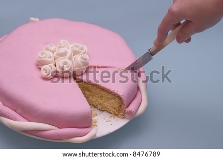 closeup of a cake. Hand cutting a slice with a knife. Fondant cake made with marshmallows
