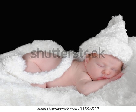 adorable newborn in hat sleeping on a white blanket.isolated on black