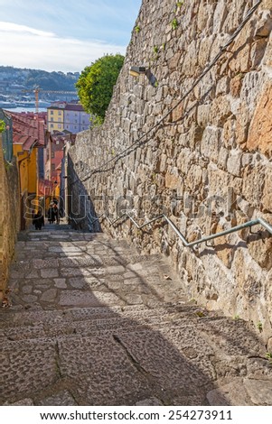The typical narrow and steep medieval street of the older parts of the city, connecting the Cathedral zone to the Ribeira District.  of Porto, Portugal. Unesco World Heritage Site