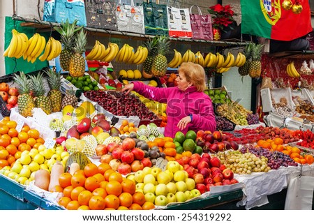 Porto, Portugal. December 29, 2014: Fruit seller organizing and taking care of the stand in the interior of the historical Bolhao Market