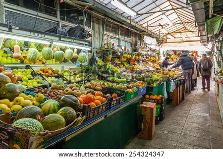 Porto, Portugal. December 29, 2014: Fruit seller and buyers in the interior of the historical Bolhao Market