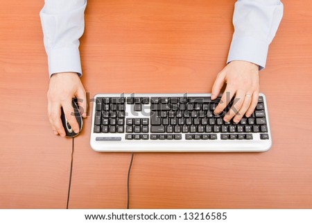 Man typing in the computer keyboard and using a mouse