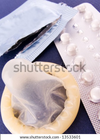Birth Control Pills and a Condom. Contraception methods.