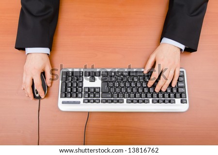 Man typing in the computer keyboard and using a mouse
