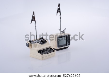 Retro styled tiny television and typewriter model on a white background