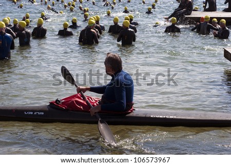 FREDERICIA, DENMARK - JULY 1: Male elite triathlon athletes and one kayak just before start in Danish Triathlon Championship 2012 July 1 in Fredericia, Denmark.