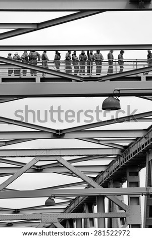 MIDDELFART, DENMARK - MAY 23, 2015: Group of people in gray coveralls on guided tour on top of the Old Little Belt Bridge.
