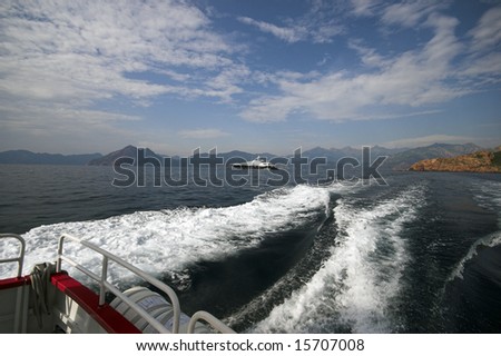 Mountain and Luxury Boat. Mediterranean Sea, Wake, Boat  and Corsican Mountain Rocks. Coastline outside Porto, Corse-Du-Sud, Corsica, France