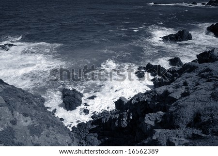 Blue Coastline. Where the waves crash against the rock cliff