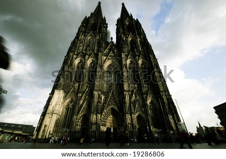 Evening Cologne Cathedral. Famous International Landmark in Germany. UNESCO World Heritage Site. Blurred people walking near the church.