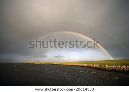 A double rainbow breaks through the storm and rain clouds