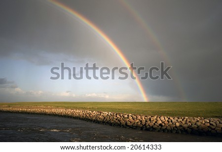 Part of double rainbow. A rainbow breaks through the storm and rain clouds