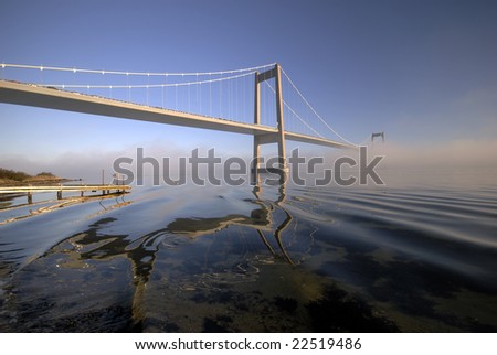 Beautiful suspension bridge.  Blue and cold foggy day in Denmark
