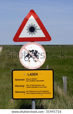 Laser light warning sign near military shooting area in Denmark. Danish, German and English text.