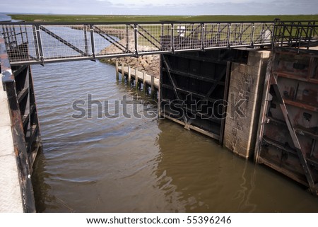 Open lock gate and small bridge over lock chamber close to Ribe River in Denmark.