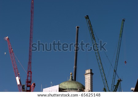 Construction cranes outdoors sky blue and high up in London, England.