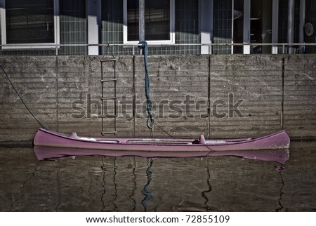 Purple canoe in Danish river close to house