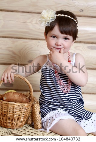 the cheerful little girl and bakery products in a basket