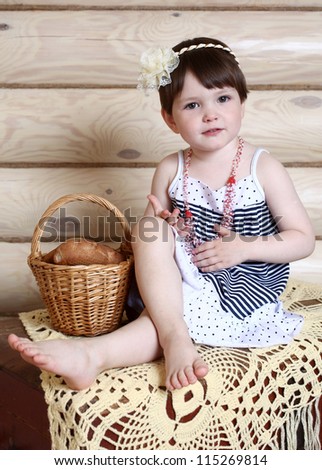 the cheerful little girl and bakery products in a basket