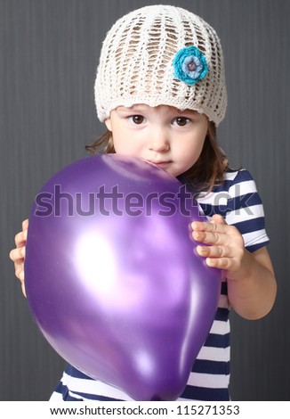 the cheerful girl with a balloon against a dark background