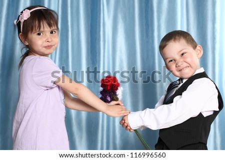 the boy and the girl hold flowers