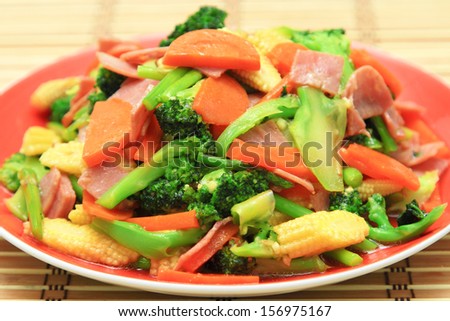 stir fried vegetables in red dish.