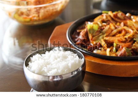 korean beef barbeque with rice cakes and rice on a side and Korean sauce.
