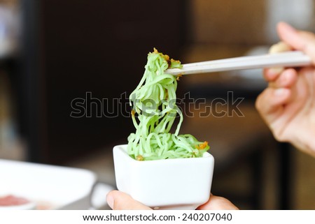 green noodle with Fried garlic in white cup.