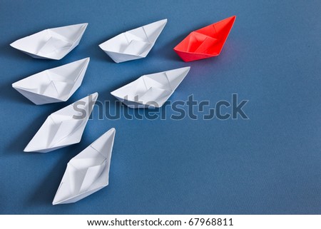 White paper boats and one red boat.