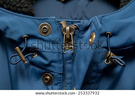 Zipper and button on outerwear clothes close up