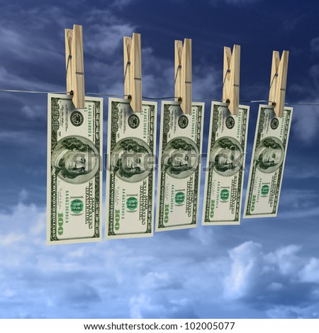 Money laundering on clothes line with wooden clothes pegs with sky background