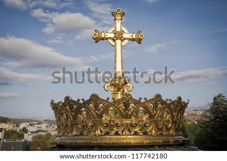 Gilded crown and cross of the dome of the Basilica of Our Lady of the Rosary of Lourdes, France. The crown symbolizes the power and glory of God and is donated by Irish pilgrims many years ago.