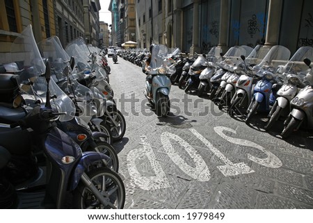 Lots of parked scooters and motorbikes in the center of Florence Italy.