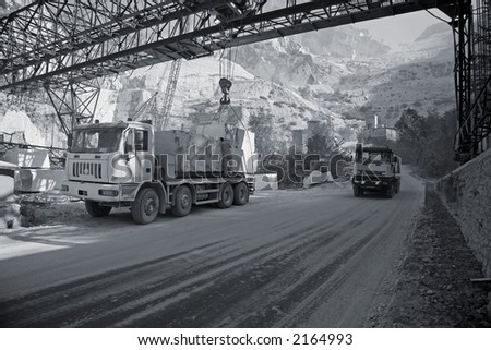 Marble quarry in the mountains near Carrara - Tuscany - Italy. A lorry is being loaded with big blocks of marble for transport.
