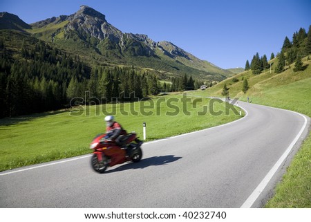 Speedy motorbike on mountain road - Dolomites, Italy.